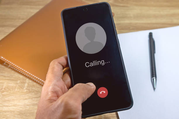 istock Hand holding a smartphone with outgoing call screen concept. Call someone with a voice call. 2159794132