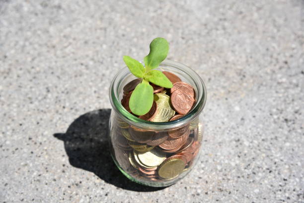 Euro coins are being collected in a glass jar, symbolizing saving and financial planning