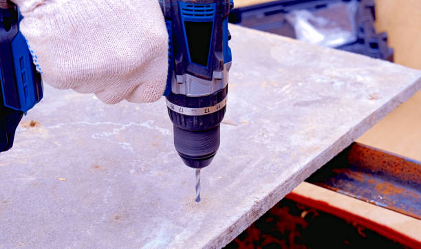 istock A worker's hands drill plywood with a battery-powered electric drill, close-up 2159796811