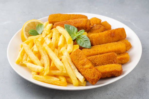 istock Fish and chips .Close up of crispy breaded deep fried fish fingers with breadcrumbs served with remoulade sauce and lemon 2159800189