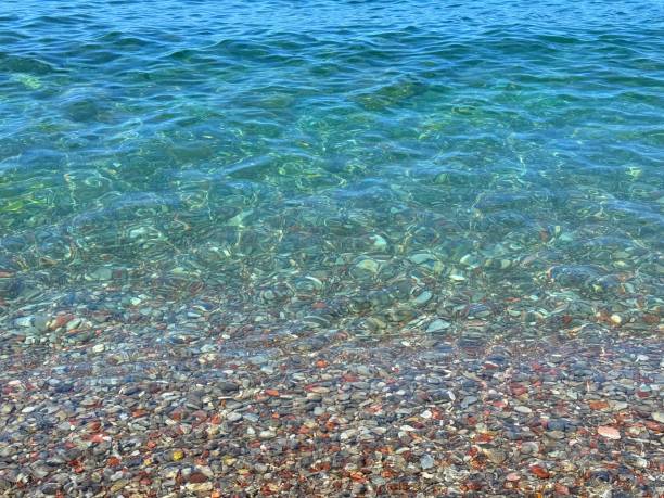 istock Sea blue clear water and pebbles 2159800638