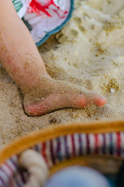 istock Baby's foot in the sand stock photo 2159802904