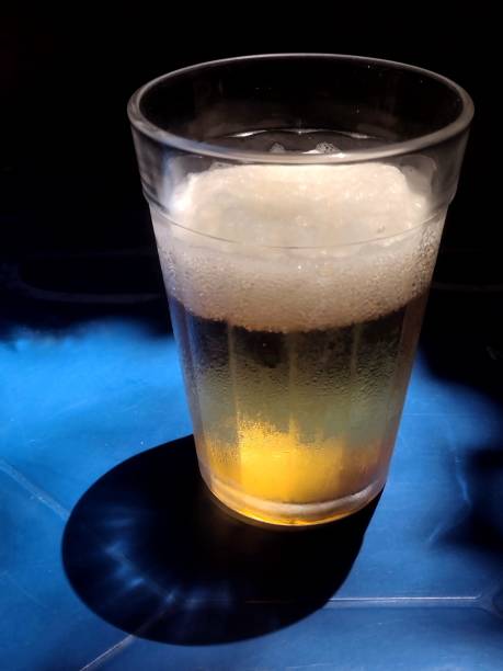 istock glass of cold beer on a blue plastic table 2159803452