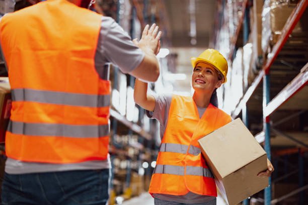 istock Two warehouse workers giving high five for successful job while standing in storage 2159805777