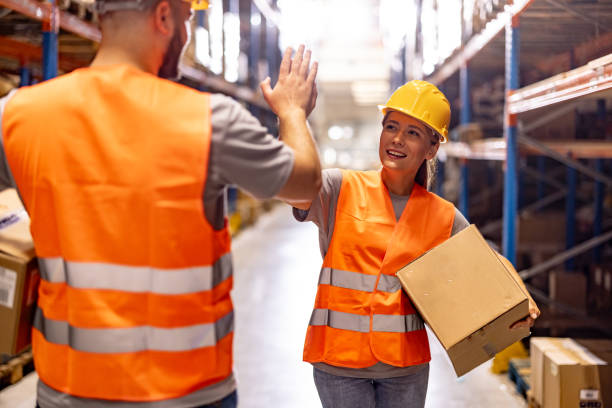 istock Two warehouse workers giving high five for successful job while standing in storage 2159805781