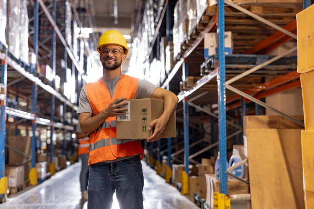 istock Portrait of smiling warehouse worker with box 2159806020