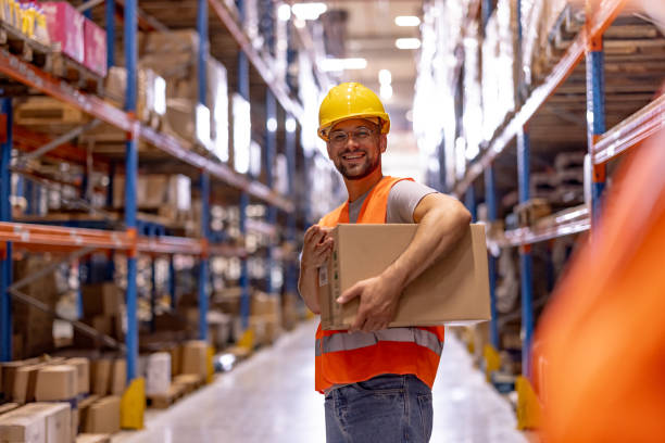 istock Portrait of smiling warehouse worker with box 2159806176