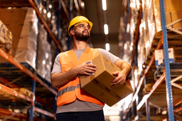 istock Portrait of smiling warehouse worker with box 2159806177