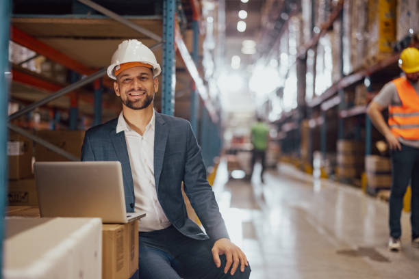 istock Happy male factory manager using laptop in warehouse 2159806220
