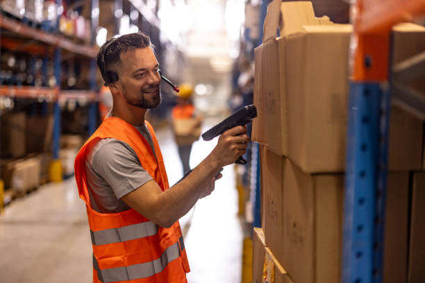 istock Portrait of smiling warehouse worker scanning box 2159806361