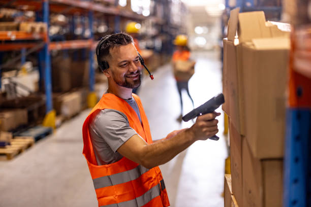 istock Portrait of smiling warehouse worker scanning box 2159806362