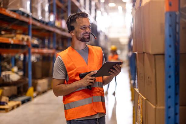 istock Portrait of smiling warehouse worker scanning box 2159806396