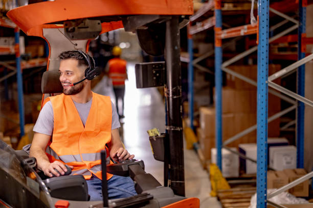 istock Happy male worker driving forklift at distribution warehouse 2159806549