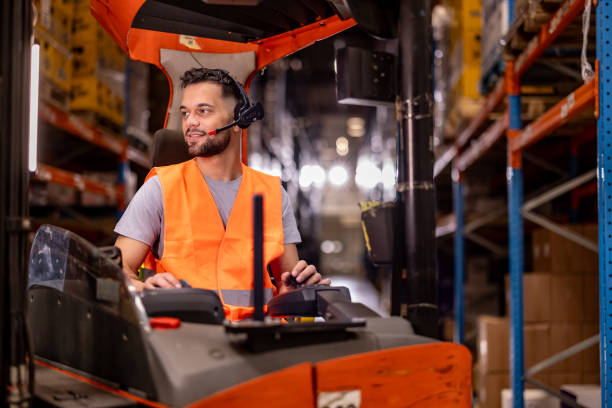 istock Happy male worker driving forklift at distribution warehouse 2159806557