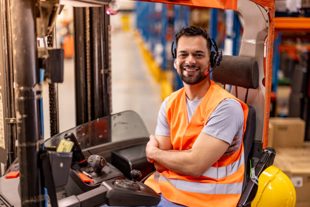istock Happy male worker driving forklift at distribution warehouse 2159807336