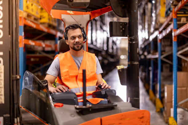 istock Happy male worker driving forklift at distribution warehouse 2159807575