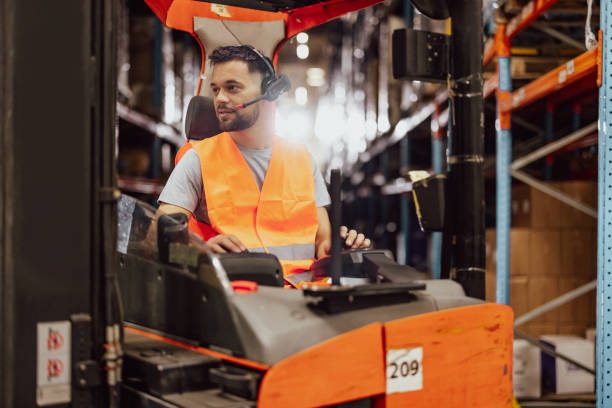 istock Happy male worker driving forklift at distribution warehouse 2159807583