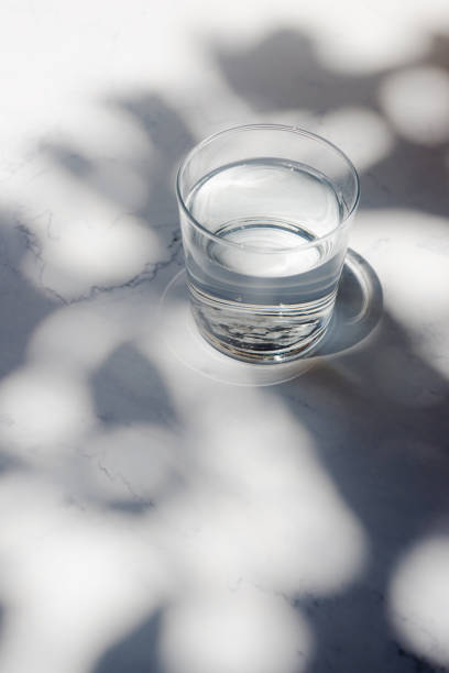 istock a glass of drinking water on white marble table. 2159807705