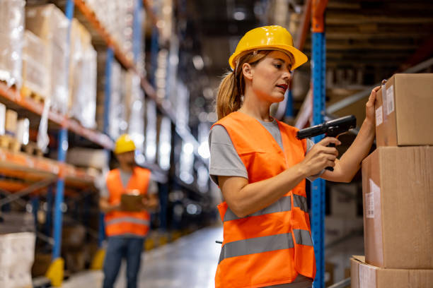 istock Female warehouse worker scanning packages at storage 2159807870