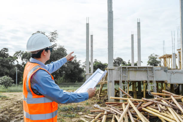istock Male Asian construction contractor engineer checks structural plans, engineers concrete columns and beams of a new house. 2159808475
