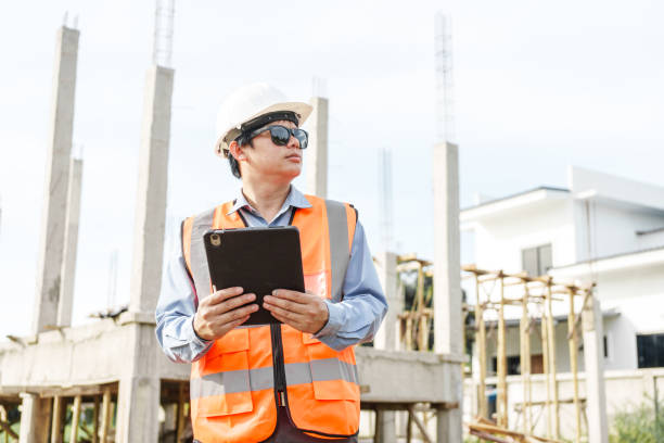 istock Male Asian construction contractor engineer checks structural plans, engineers concrete columns and beams of a new house. 2159808485