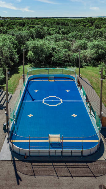 Saint-Hugues, Quebec, Canada, June 28, 2024. Aerial view of a vibrant deck hockey  The bright blue rink contrasts with the surrounding green fields. The image showcases the outdoor recreational spirit, the modern facilities, and the scenic beauty of the small town.\
