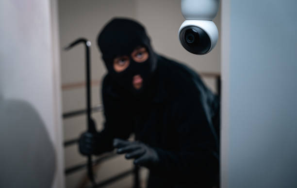 istock Security camera.Thief in uniform black jacket various action housebreak. The Robber terrorism criminal escapes with balaclava and crowbar entering a house for stealing Housebreak at night 2159812756