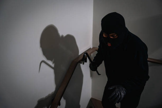 istock Thief in uniform black jacket various action housebreak. The Robber terrorism criminal escapes with balaclava and crowbar entering a house for stealing Housebreak at night 2159812762