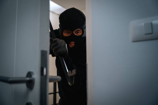 istock Thief in uniform black jacket various action housebreak. The Robber terrorism criminal escapes with balaclava and crowbar entering a house for stealing Housebreak at night 2159813400