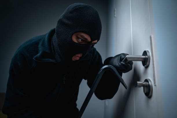 Thief in uniform black jacket various action housebreak. The Robber terrorism criminal escapes with balaclava and crowbar entering a house for stealing Housebreak at night