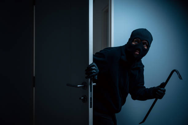 istock Thief in uniform black jacket various action housebreak. The Robber terrorism criminal escapes with balaclava and crowbar entering a house for stealing Housebreak at night 2159815289