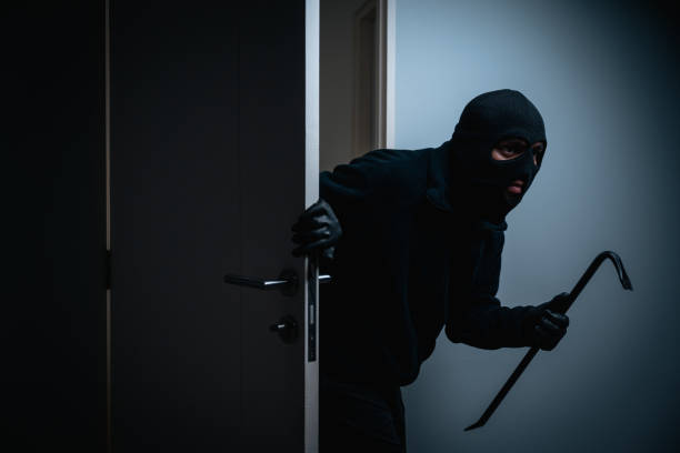 istock Thief in uniform black jacket various action housebreak. The Robber terrorism criminal escapes with balaclava and crowbar entering a house for stealing Housebreak at night 2159815577