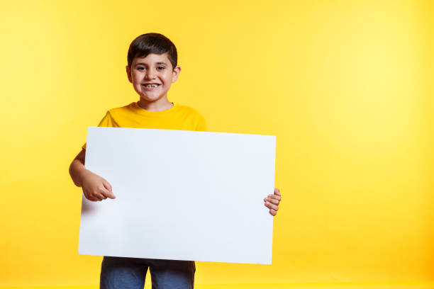 istock A young boy is holding a white board with a smile on his face 2159820914