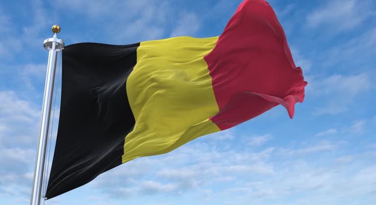Belgium flag with flagpole waving in rolling clouds looping, 4K Perfect Loop