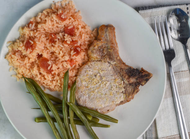 istock pork chop served with green beans and rice 2159823728