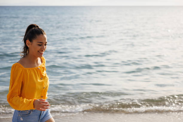 istock Happy young woman on the beach 2159828917