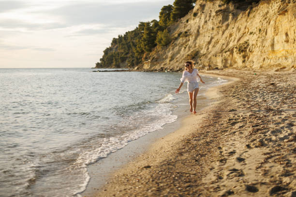 istock Happy young woman on the beach 2159829665
