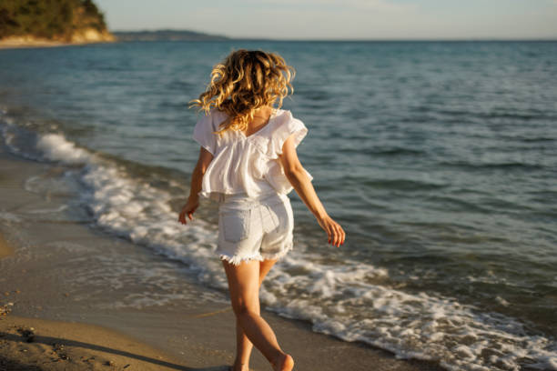 istock Happy young woman on the beach 2159829823