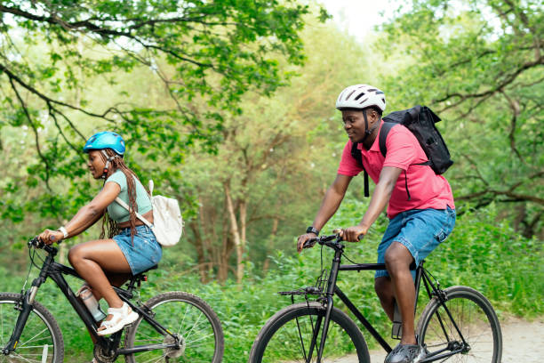 istock Young couple riding bicycle in summer park 2159830839