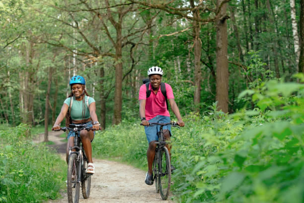 istock Young couple riding bicycle in summer park 2159830869