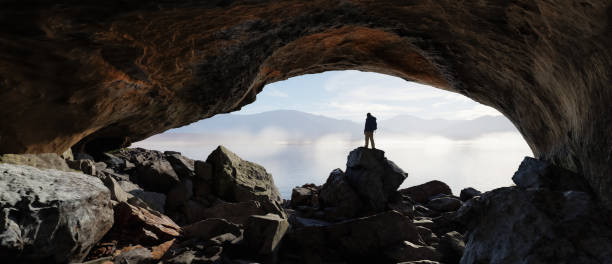 istock Adult adventurous man standing in a cave. 3d rendering mountain adventure artwork. 2159832364