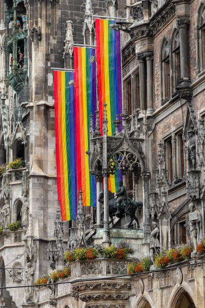 Rainbow Pride flags hanging on the exterior of the New Town Hall, in Munich's Marienplatz historic district. The flags are put up during Munich's Gay Pride event, known as Christopher Street Day. It is held in the Bavarian city in June each year and starts with a procession parade from Marienplatz. It is an event where people bring attention and pride to the different gender, they or others identify as.