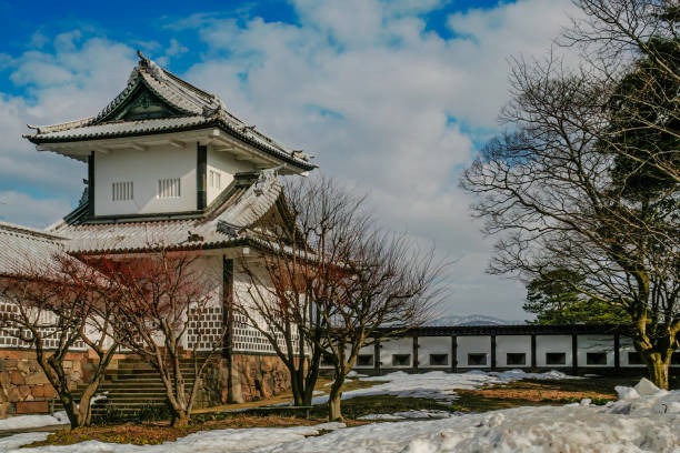 Kanazawa, Japan - 2nd March 2018 - view of Kanazawa Castle, a symbol of Japan feudal history and cultural heritage. The castle white plastered walls and multi-tiered, lead-tiled roofs stand out against a clear blue sky. The elegance of the castle is accentuated by its Ishigaki stone walls and crafted wooden gates.