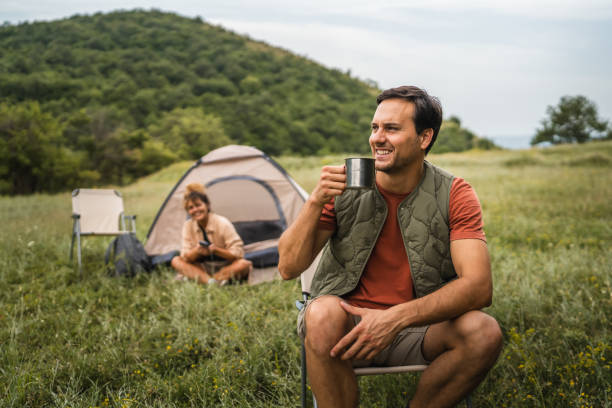 istock Boyfriend prepare coffee while camp with girlfriend in the background 2159842593