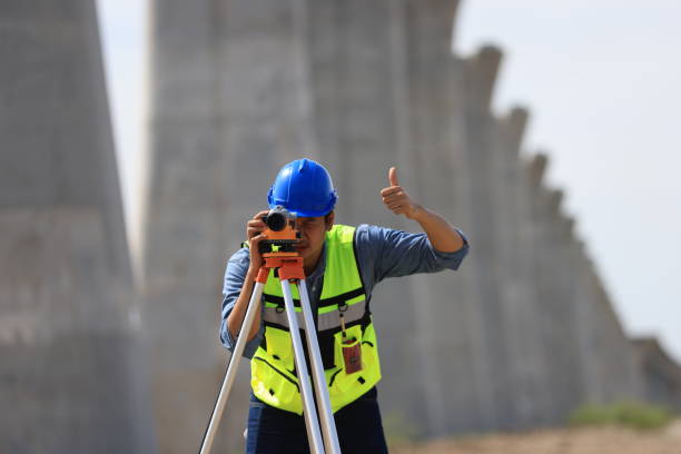 Surveying measuring equipment level transit on tripod at construction building