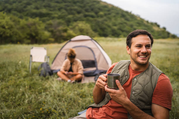 istock Boyfriend prepare coffee while camp with girlfriend in the background 2159843314