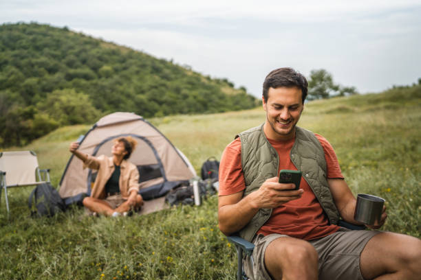 istock Boyfriend use mobile phone on camp with girlfriend in the background 2159843728