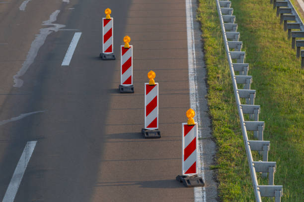 Red white traffic cones or pylons on gray background copy space. Traffic cones are often used to during road construction project or car accidents. Abstract warning sign, caution, alert symbol concept