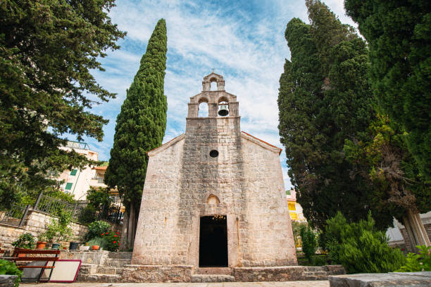 istock Stone-built monastery in Montenegro with a towering bell structure, blending historical charm with summer skies. 2159850505