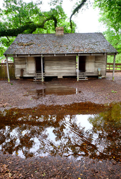 Vacherie, Louisiana -- May 3, 2017: This slave hut is one of the twenty duplex structures that housed approximately 100 slaves. The slave community, comprised of men, women and children, worked in the field or in the Oak Alley mansion. Following the Civil War and the abolition of slavery, many formerly enslaved individuals found themselves trapped in sharecropping arrangements, struggling to pay off debts and secure a better future.